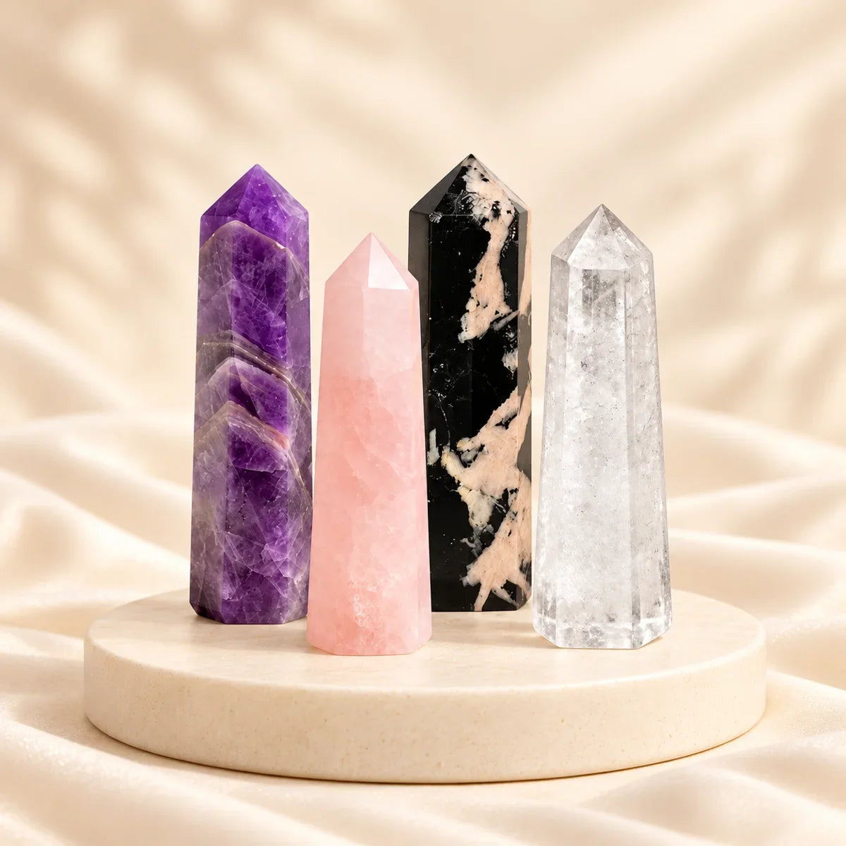 Amethyst, Rose Quartz, Black Tourmaline and Clear Quartz towers on a warm ivory background