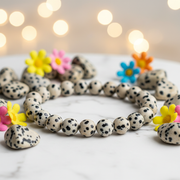 Natural Dalmatian Jasper Bracelet on white marble with jasper stones and colorful flowers
