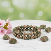 Natural Unakite Bracelet on white marble with unakite stones and pink flowers