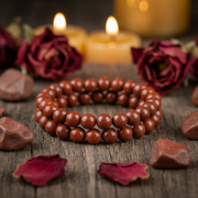 Natural Red Jasper Bracelet on dark wood with red jasper stones and candlelight