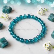 Natural Apatite Bracelet on white marble with teal apatite stones and white flowers